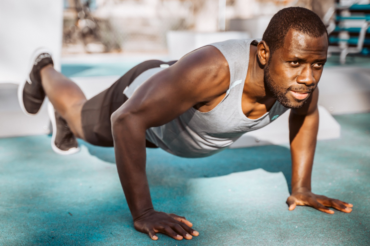 Man does a pushup with his right foot lifted off the ground.