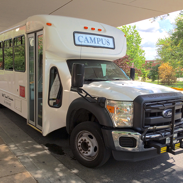 An NIH campus shuttle bus arrives at a stop.