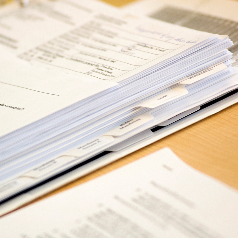 Binder with papers on office desk.