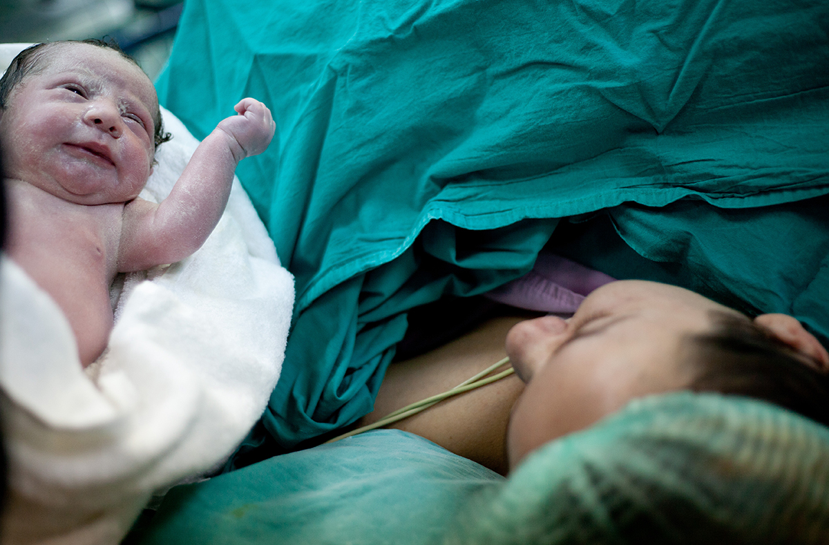 Newborn baby next to mother in hospital birth setting