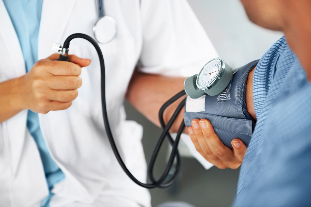  Image of a medical professional taking a person’s blood pressure