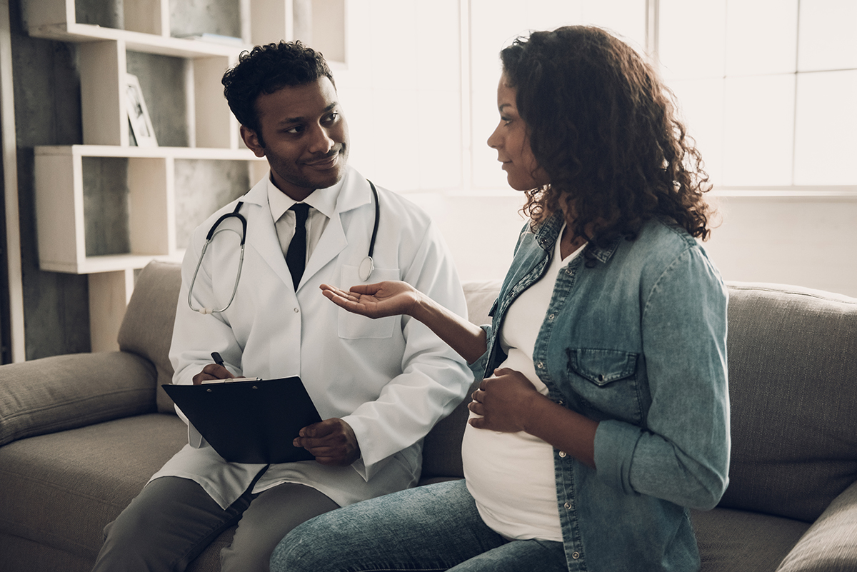 Doctor in White Uniform Consulting Pregnant Woman.