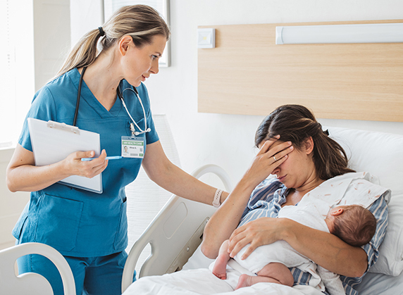 Image of a woman in a hospital bed holding a baby