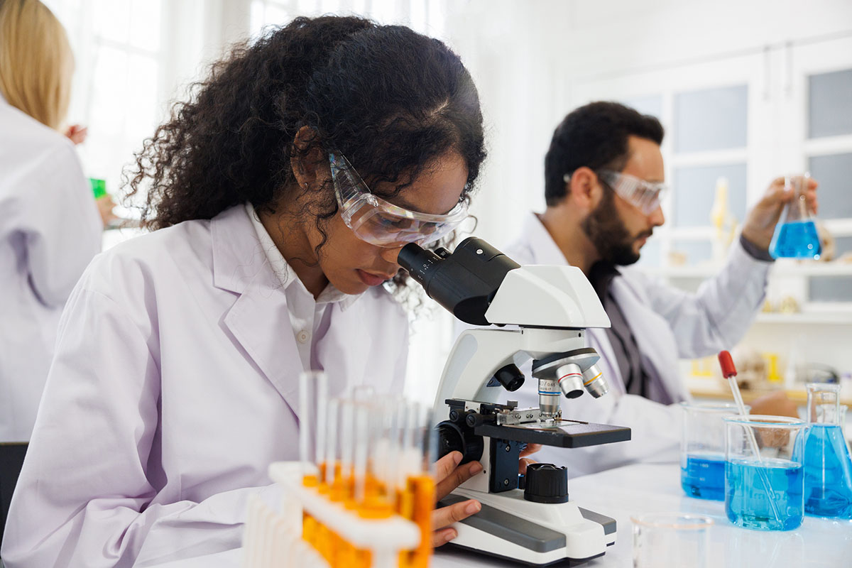 Image of a scientist looking through a microscope