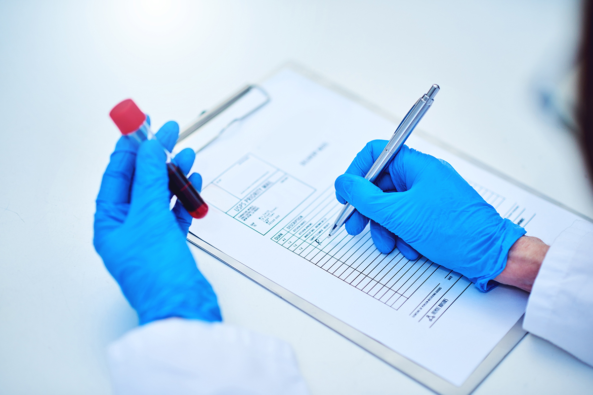 Image of a researcher holding a test tube with a blood sample.