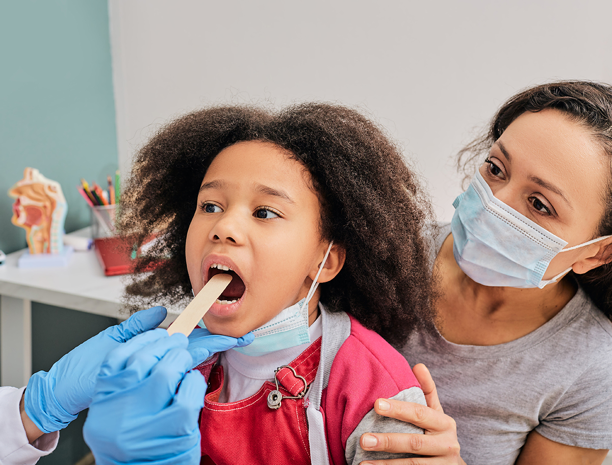 image of a young girl receiving a tonsil exam.