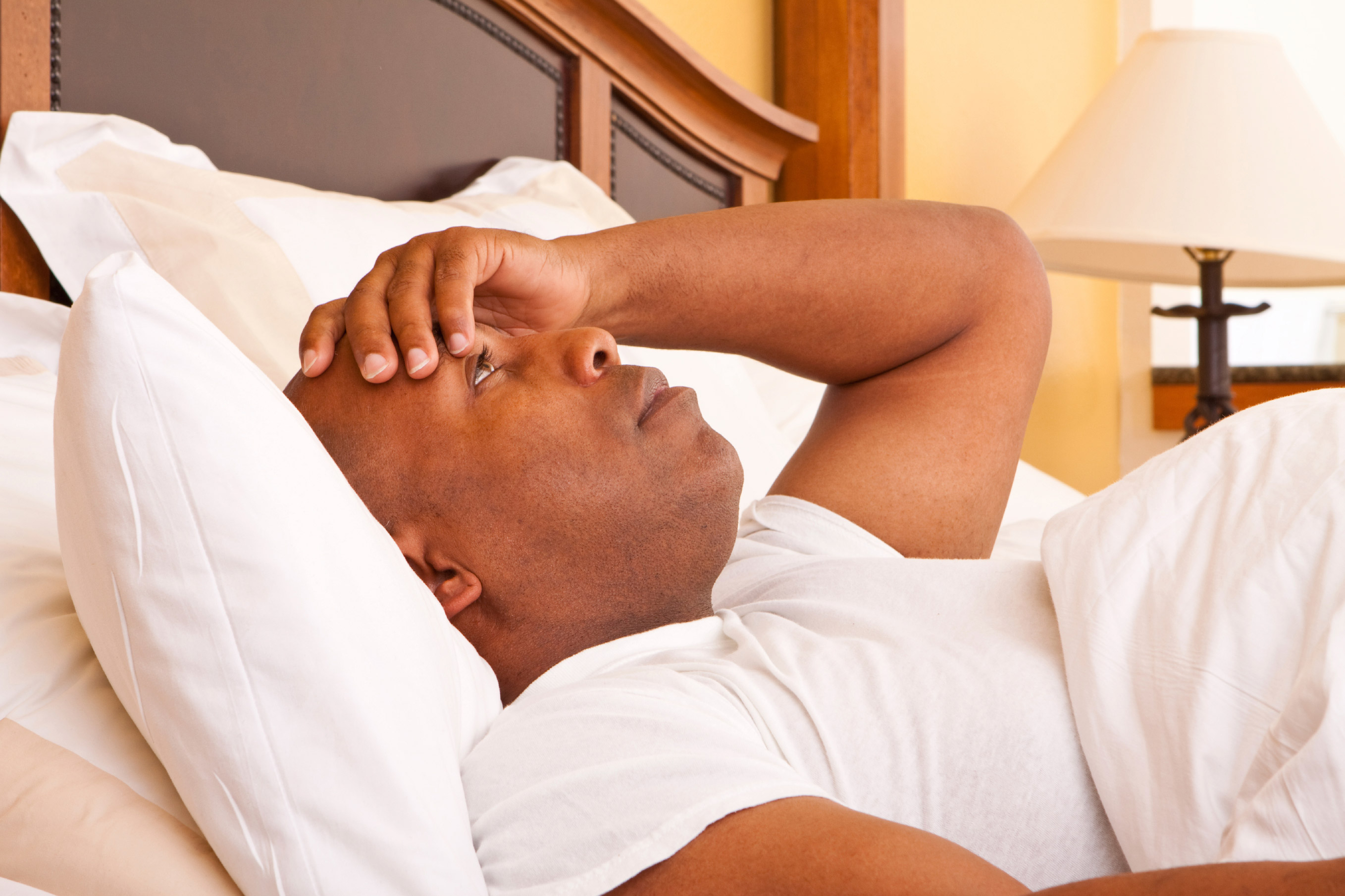 a photo of a man lying awake in bed