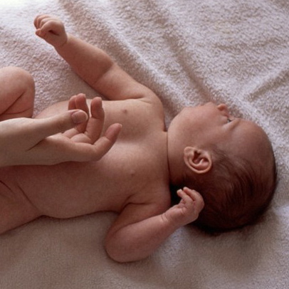 Photo of a mother’s hands touching her infant - cropped