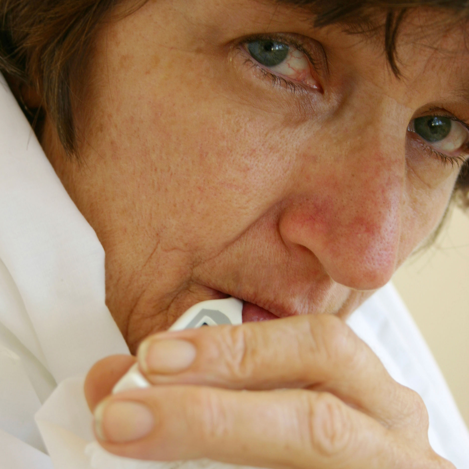 Woman holding a crumpled tissue.