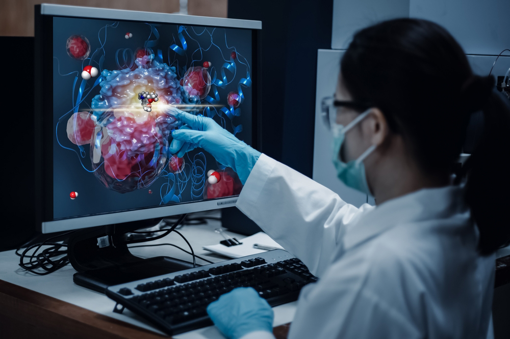 A researcher pointing to a molecular structure on a computer monitor. A researcher pointing to a molecular structure on a computer monitor.