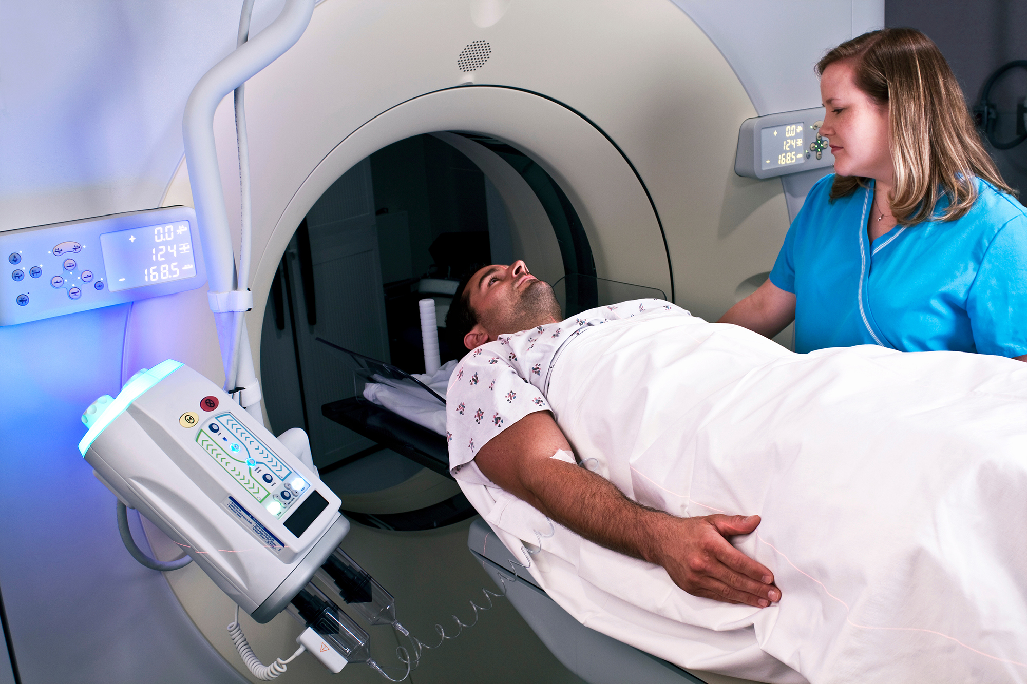 Technician preparing man for a CT scan. Technician preparing man for a CT scan.