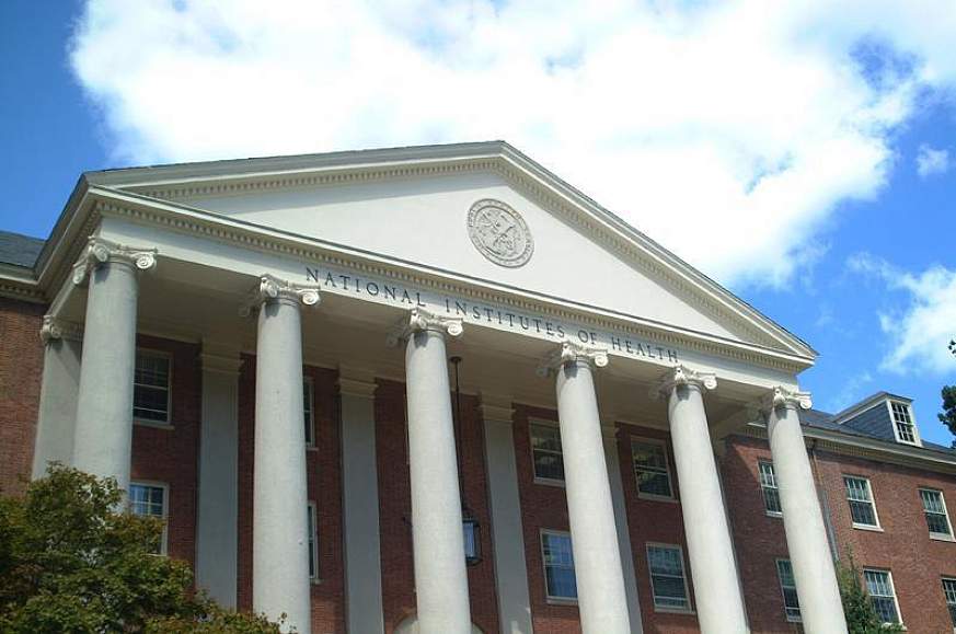 Looking up at Building 1 on a partly-cloudy day.