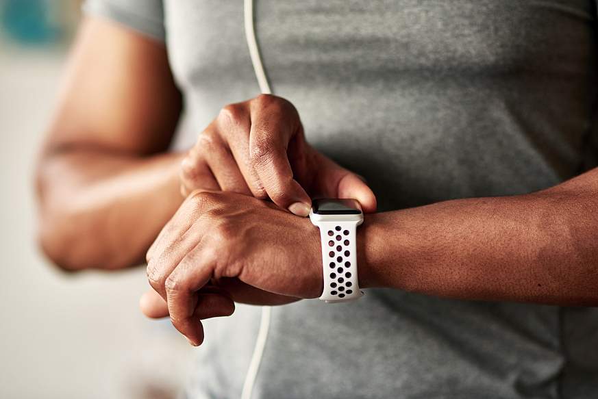 Fitness man taking a break, checking activity tracker