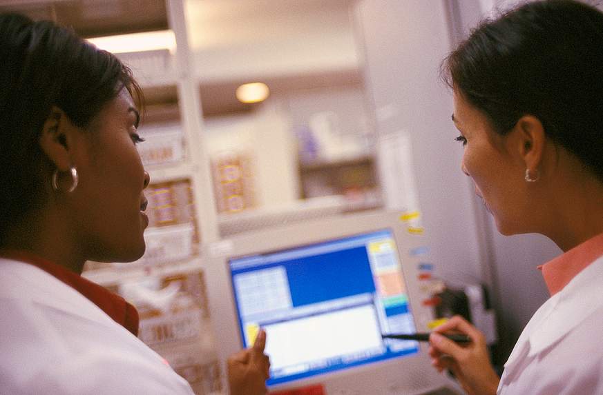 Two medical workers looking at a computer screen Two medical workers looking at a computer screen.