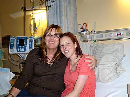 Weller and her daughter Lauren Weller and her daughter, sitting on a hospital bed, smile for the camera.