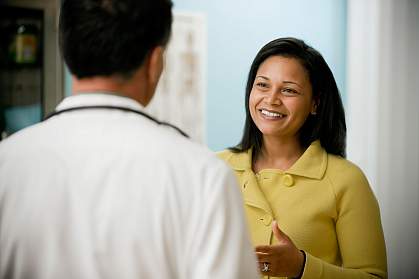Young Smiling Woman and Male Doctor A potential volunteer talks with her doctor about participating in a clinical trial.