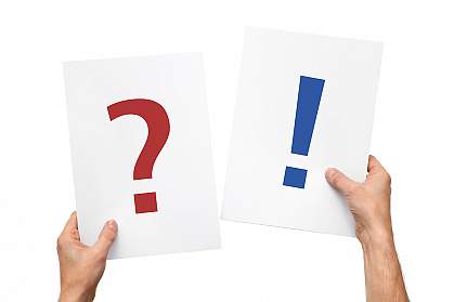 Hands holding up question and answer cards Hands holding up two cards - one displaying a large question mark and the other an exclamation mark.