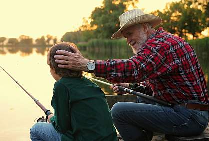 Man chatting with his grandson while fishing. Man chatting with his grandson while fishing.