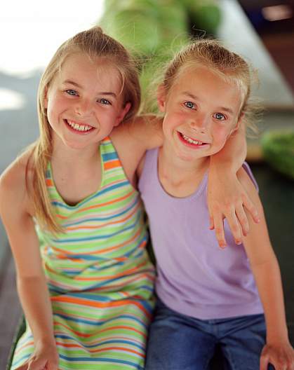 photo of two young girls smiling photo of two young girls smiling