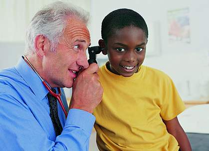 doctor examining a young boy's ear doctor examining a young boy's ear