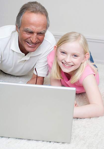 Picture of a grandfather assisting his son and grandson at the computer Picture of a grandfather assisting his son and grandson at the computer
