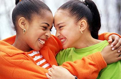 Two young African American girls smiling at each other Two young African American girls smiling at each other