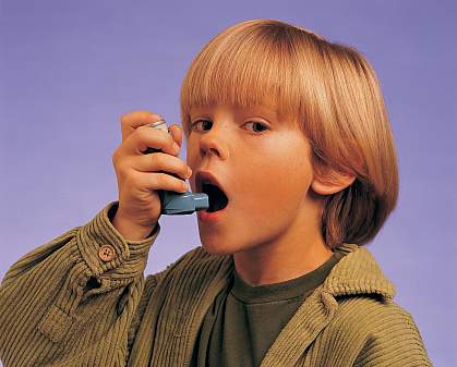 A young boy using an inhaler A young boy using an inhaler