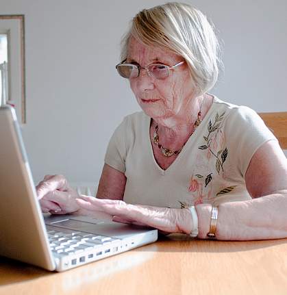 Photo of an older woman reading from her laptop Photo of an older woman reading from her laptop