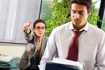 A female boss yelling at a male employee A female boss yelling at a male employee