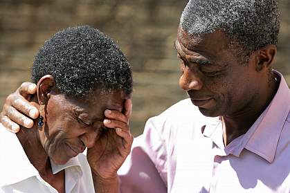 Photo of an African-American man comforting an African-American woman