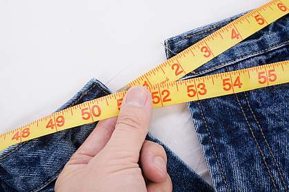 Photo of a person taking a waist measurement Photo of a person taking a waist measurement