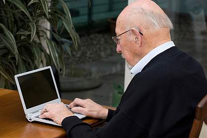 Photo of an older man using a laptop computer Photo of an older man using a laptop computer