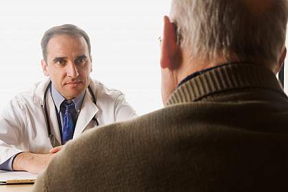 A photo of an older man consulting with his doctor A photo of an older man consulting with his doctor