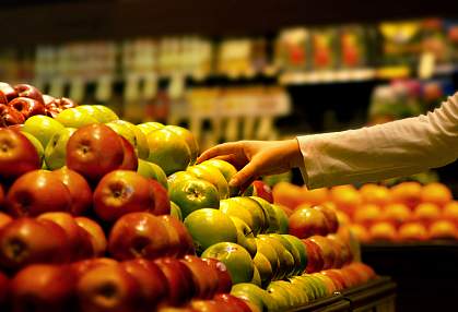A photo of a hand picking up an apple at the supermarket A photo of a hand picking up an apple at the supermarket
