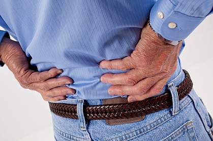 Photo of a man clutching his lower back Photo of a man clutching his lower back