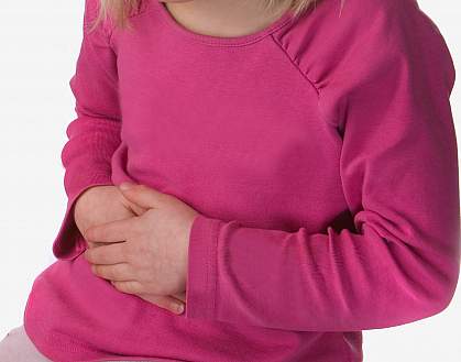 photo of a young girl holding her stomach photo of a young girl holding her stomach