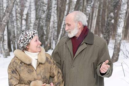 Photo of an older couple standing in the snow