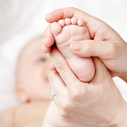 Photo of a newborn infant's foot held in a woman's hands Photo of a newborn infant's foot held in a woman's hands