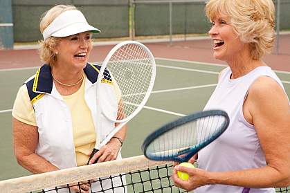 Photo of two older women playing tennis