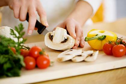 Photo of hands cutting vegetables on a cutting board