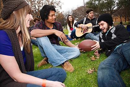 Photo of college students gathered on a lawn Photo of college students gathered on a lawn