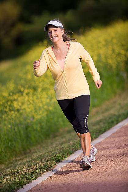 Photo of an older woman walking briskly around a track Photo of an older woman walking briskly around a track