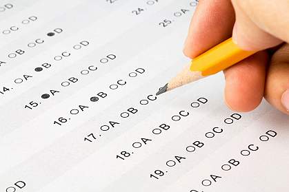 Photo of a hand with a pencil on a test sheet Photo of a hand with a pencil on a test sheet