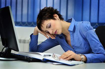 Photo of a woman nodding off at her desk Photo of a woman nodding off at her desk