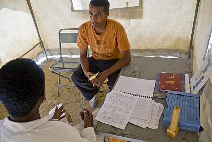 Photo of an young man talking with a doctor in a mobile clinic tent in Africa Photo of an young man talking with a doctor in a mobile clinic tent in Africa
