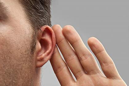 Photo of a man holding hand up to his ear Photo of a man holding hand up to his ear