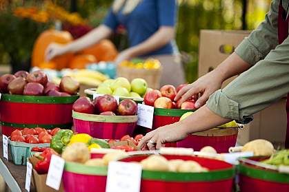 Photo of people reaching for fresh fruit at a farmer’s market