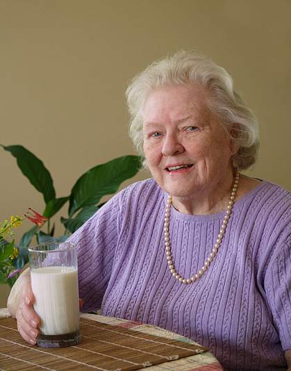 Photo of an older woman with a glass of milk Photo of an older woman with a glass of milk.