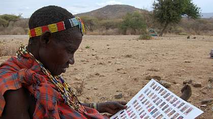 Hadza woman looking at a sheet with photos of other Hadza people Hadza woman looking at a sheet with photos of other Hadza people.