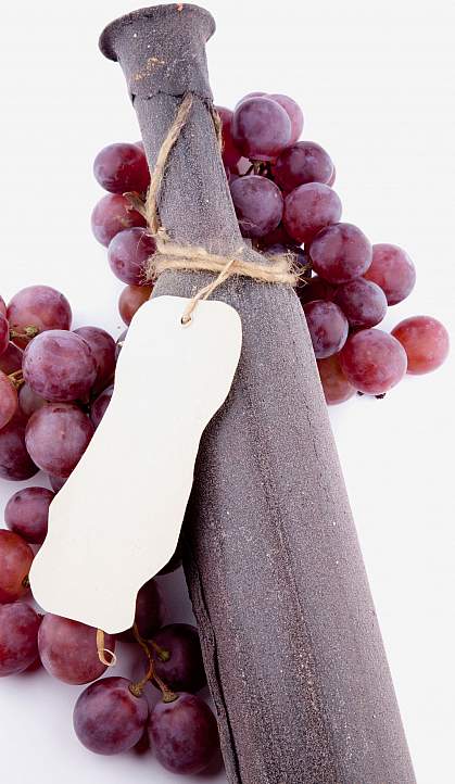 Grapes around a wine bottle.